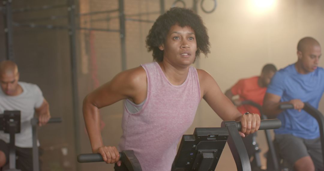 Fit Woman Exercising on Gym Bike in a Group Workout Session - Free Images, Stock Photos and Pictures on Pikwizard.com