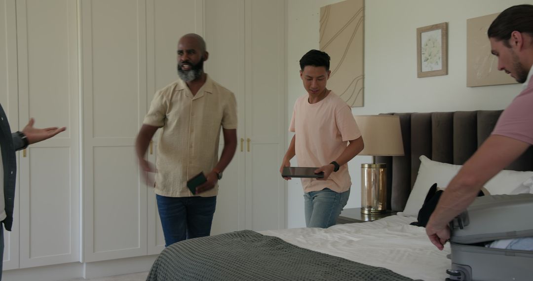 Men Organizing and Packing Suitcase in Bedroom for Travel Preparation