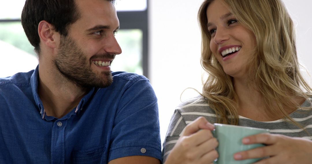 Happy couple laughing together and enjoying coffee - Free Images, Stock Photos and Pictures on Pikwizard.com