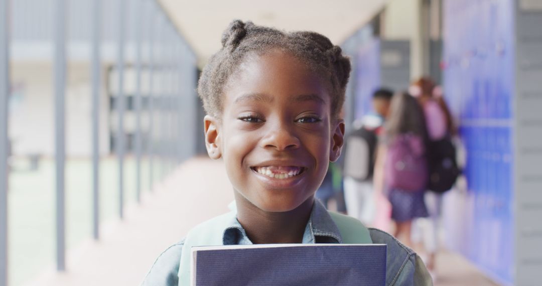 Smiling Girl Holding Book in School Hallway - Free Images, Stock Photos and Pictures on Pikwizard.com