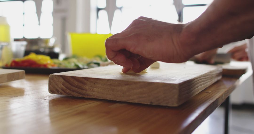 Close-Up of Hand Chopping Vegetables on Wooden Cutting Board - Free Images, Stock Photos and Pictures on Pikwizard.com