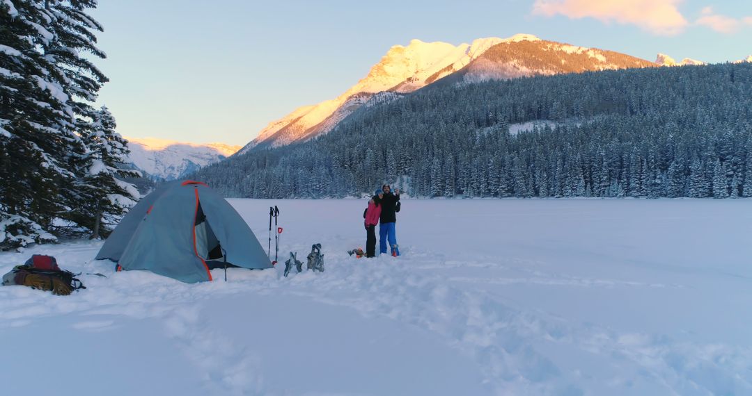 Winter Camping Family Enjoying Snowy Mountain Landscape at Sunset - Free Images, Stock Photos and Pictures on Pikwizard.com