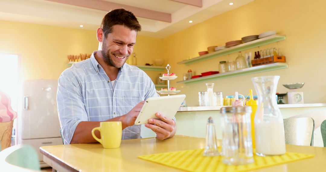 Smiling Man Using Digital Tablet in Modern Kitchen - Free Images, Stock Photos and Pictures on Pikwizard.com