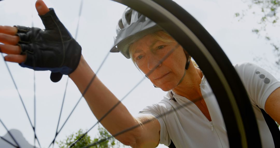 Senior Cyclist Inspecting Bicycle Tire Outdoors - Free Images, Stock Photos and Pictures on Pikwizard.com