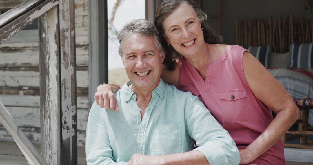 Smiling Senior Couple Relaxing by Beachfront Home