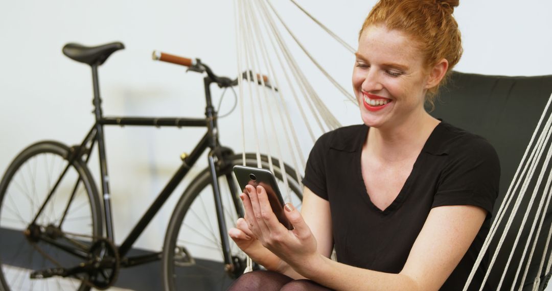 Happy Woman Relaxing on Hammock with Smartphone and Bicycle - Free Images, Stock Photos and Pictures on Pikwizard.com