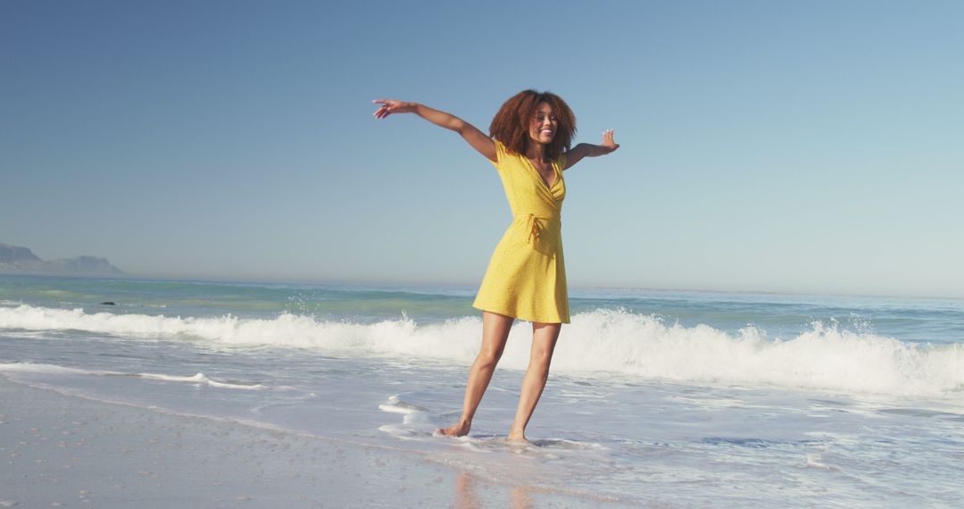 Happy biracial woman dancing on sunny beach by the sea, smiling - Free Images, Stock Photos and Pictures on Pikwizard.com