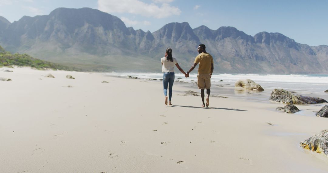 Couple Enjoying a Relaxing Walk on Sunny Beach