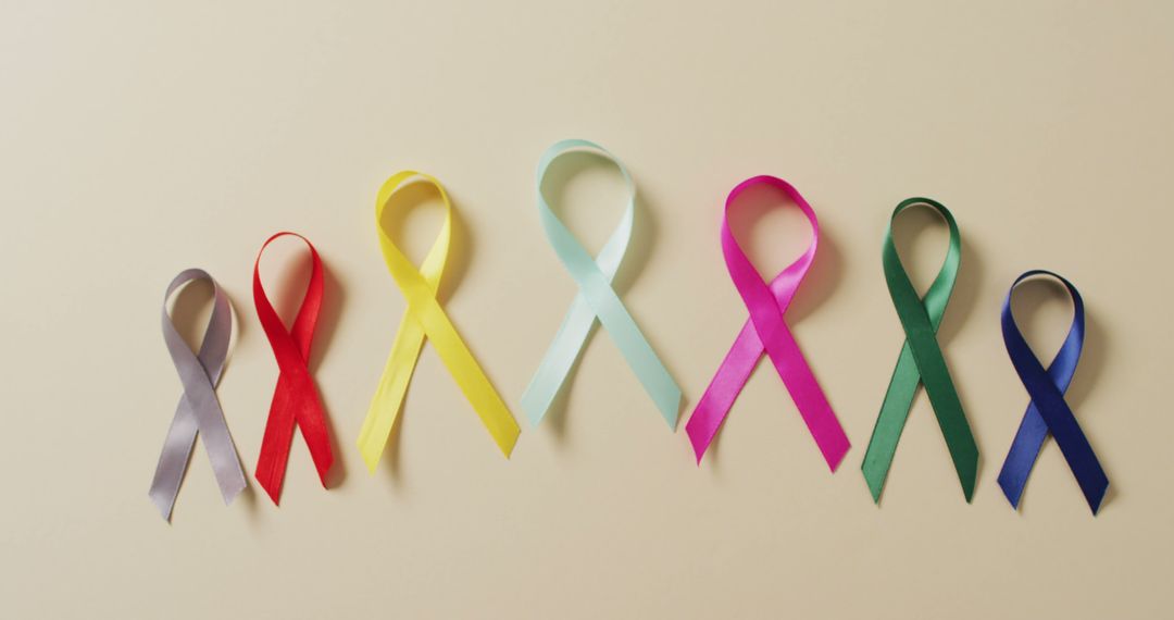 Colorful Awareness Ribbons on Beige Background Representing Various Causes - Free Images, Stock Photos and Pictures on Pikwizard.com