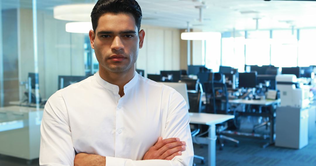 Confident Young Latino Businessman Standing with Arms Crossed in Modern Office - Free Images, Stock Photos and Pictures on Pikwizard.com