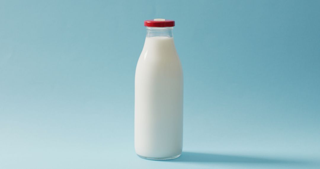 Image of glass bottle of milk on blue background - Free Images, Stock Photos and Pictures on Pikwizard.com