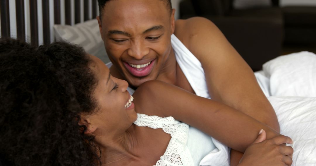 Happy African American Couple Laughing Together in Bed - Free Images, Stock Photos and Pictures on Pikwizard.com