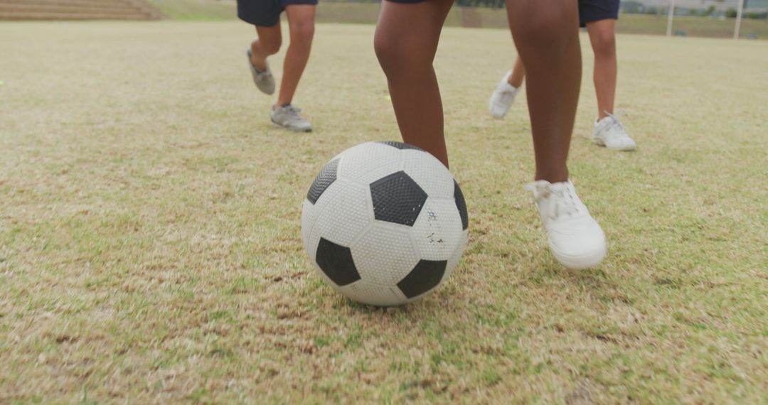 Image of legs of diverse girls playing soccer in front of school - Free Images, Stock Photos and Pictures on Pikwizard.com