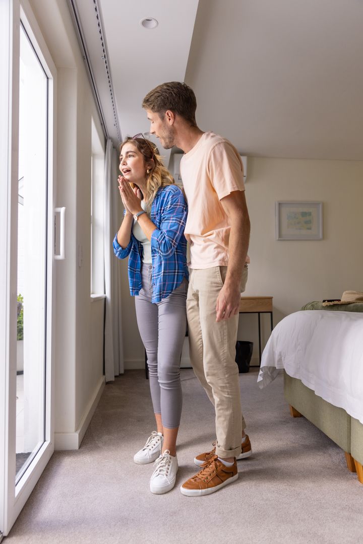 Couple Enjoying Balcony View from Comfortable Bedroom