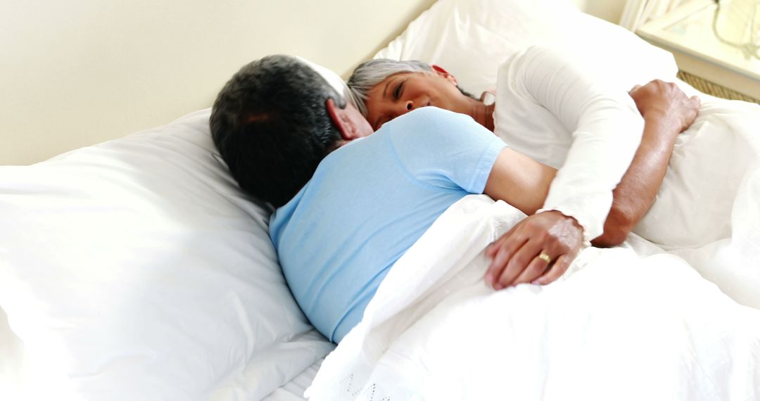 Middle-Aged Couple Embracing in Bed Displaying Deep Emotional Connection