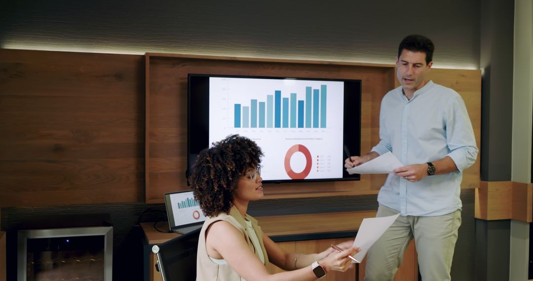 Diverse Coworkers Analyzing Data Reports in Modern Office Meeting