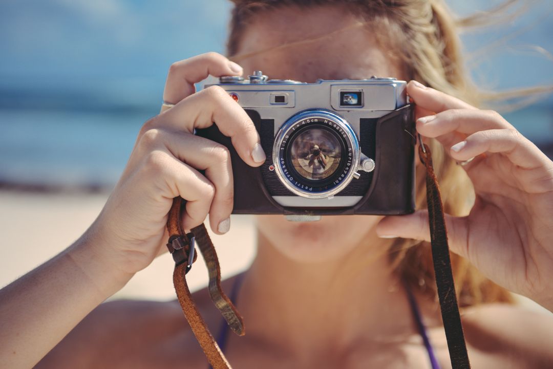 Woman Holding Vintage Camera on Beach - Free Images, Stock Photos and Pictures on Pikwizard.com
