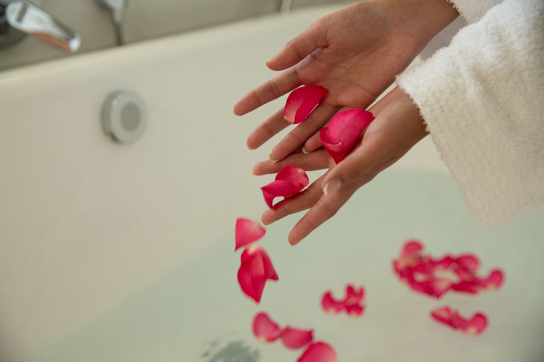 Mid section of woman putting rose petals in bathtub - Free Images, Stock Photos and Pictures on Pikwizard.com