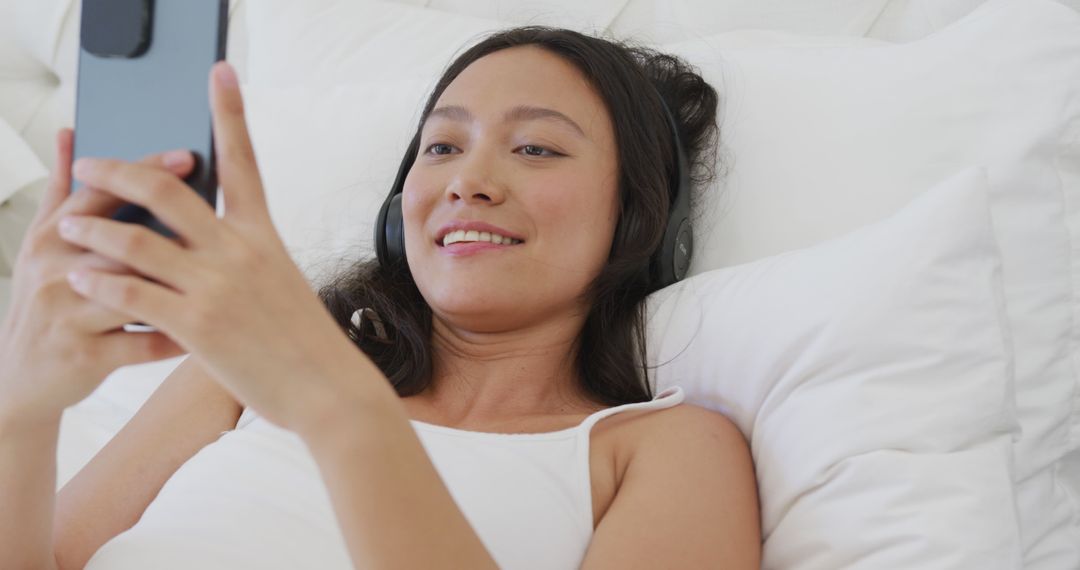 Woman Relaxing on Bed Listening to Music with Smartphone - Free Images, Stock Photos and Pictures on Pikwizard.com