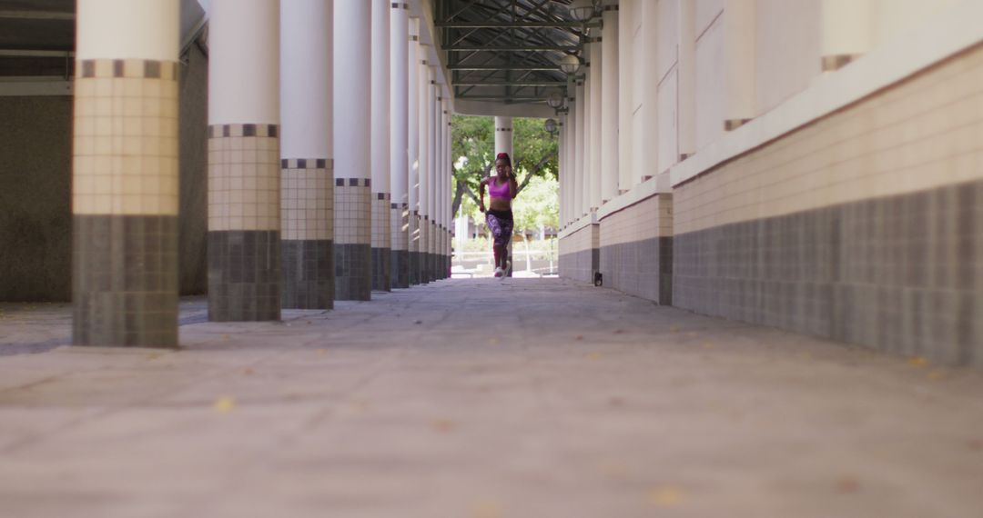 Woman Exercising in Modern Urban Corridor with Columns - Free Images, Stock Photos and Pictures on Pikwizard.com