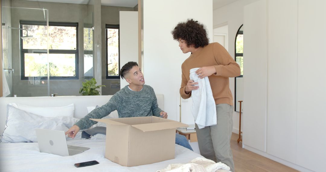 Young Men Unpacking Boxes in Modern Bedroom