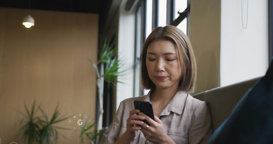 Woman Relaxing while Browsing Smartphone in Cozy Lounge Area