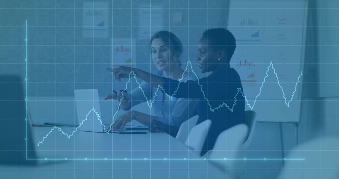 Businesswomen Analyzing Data Trends in Office with Graph Overlay