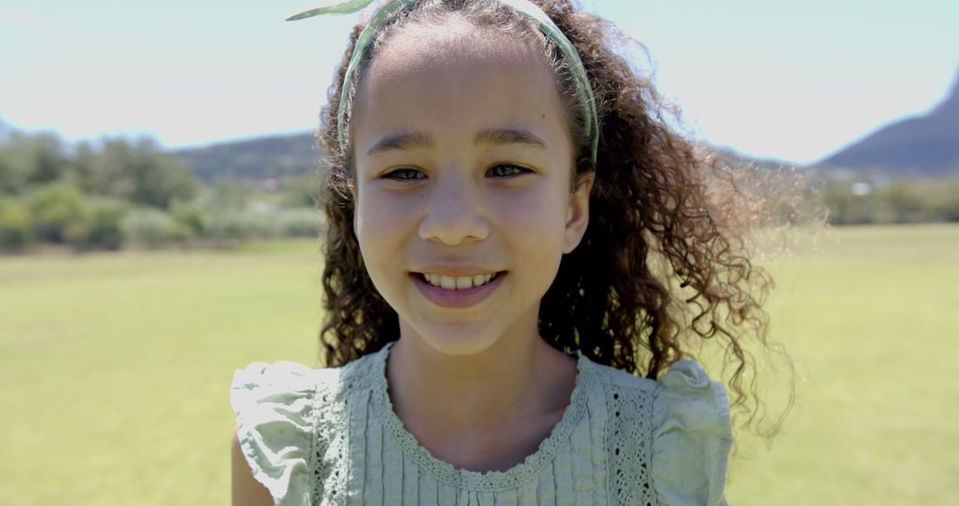 Cheerful Biracial Girl in Sunlit Field Smiling with Joy