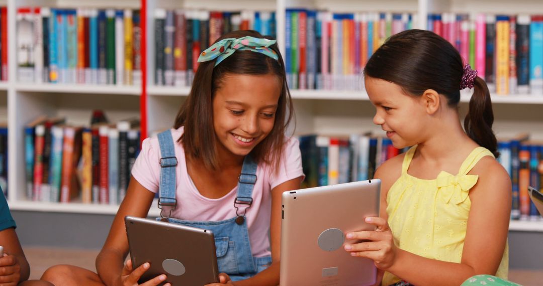 Schoolchildren Engaging with Digital Tablets in Library - Free Images, Stock Photos and Pictures on Pikwizard.com