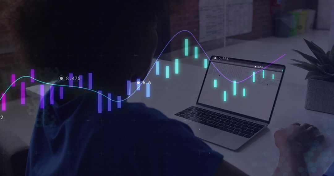 Analyst Monitoring Stock Charts on Laptop in Modern Workspace
