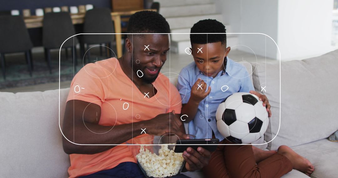 Father and Son Watching Soccer Match on Smartphone Inside Home