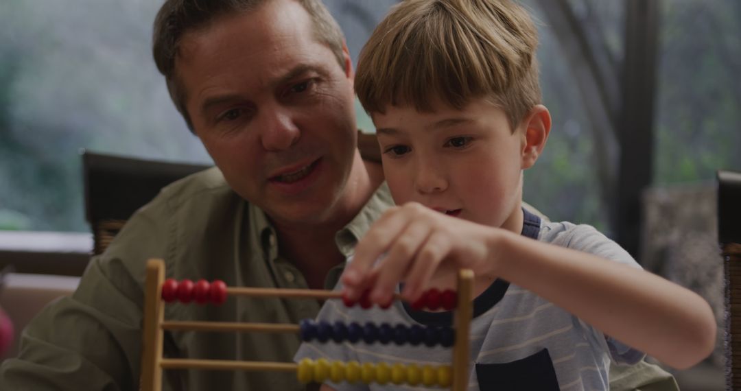 Father and Son Engaging in Educational Play with Abacus - Free Images, Stock Photos and Pictures on Pikwizard.com