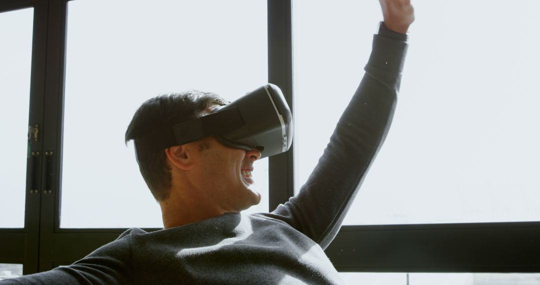 Excited Man Using Virtual Reality Headset in Bright Room - Free Images, Stock Photos and Pictures on Pikwizard.com