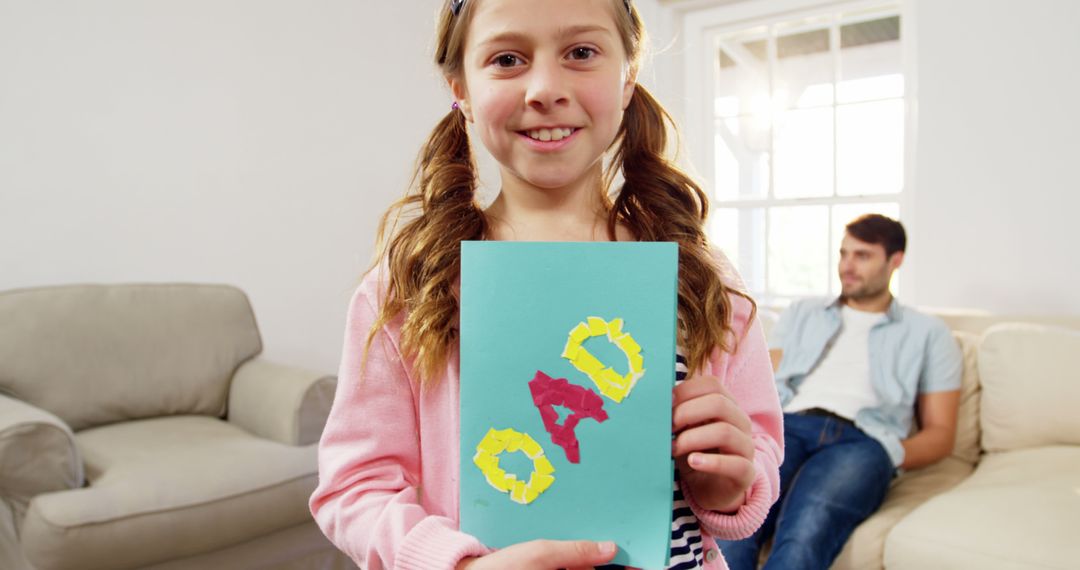 Smiling Girl Holding Handmade Father's Day Card - Free Images, Stock Photos and Pictures on Pikwizard.com