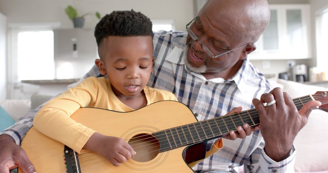 Grandfather Teaching Young Boy to Play Guitar at Home - Free Images, Stock Photos and Pictures on Pikwizard.com