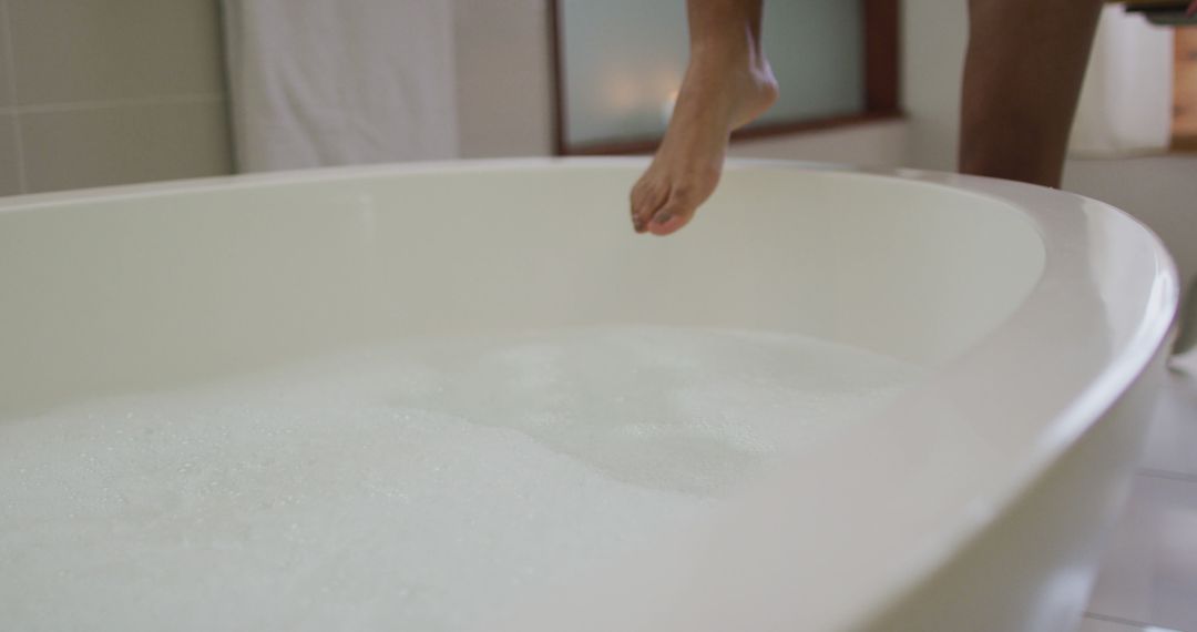 Person Preparing to Enter Bubble Bath in Modern Bathroom - Free Images, Stock Photos and Pictures on Pikwizard.com