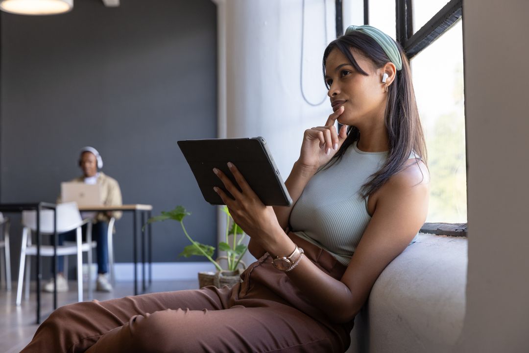 Focused Young Woman Using Tablet in Modern Co-Working Space