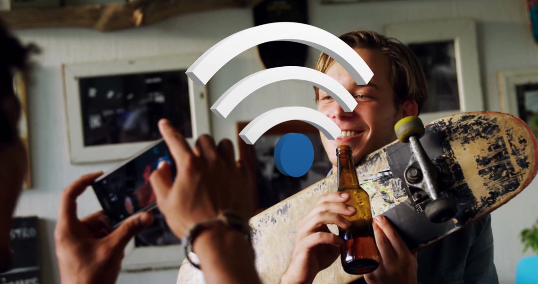 Man Holding Skateboard with Beer Smiling, Filmed by Friend Indoors