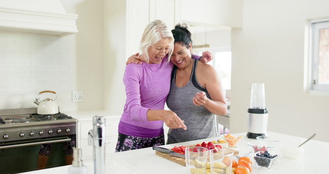 Mature Women Joyfully Preparing Healthy Meals Together in Modern Kitchen - Free Images, Stock Photos and Pictures on Pikwizard.com