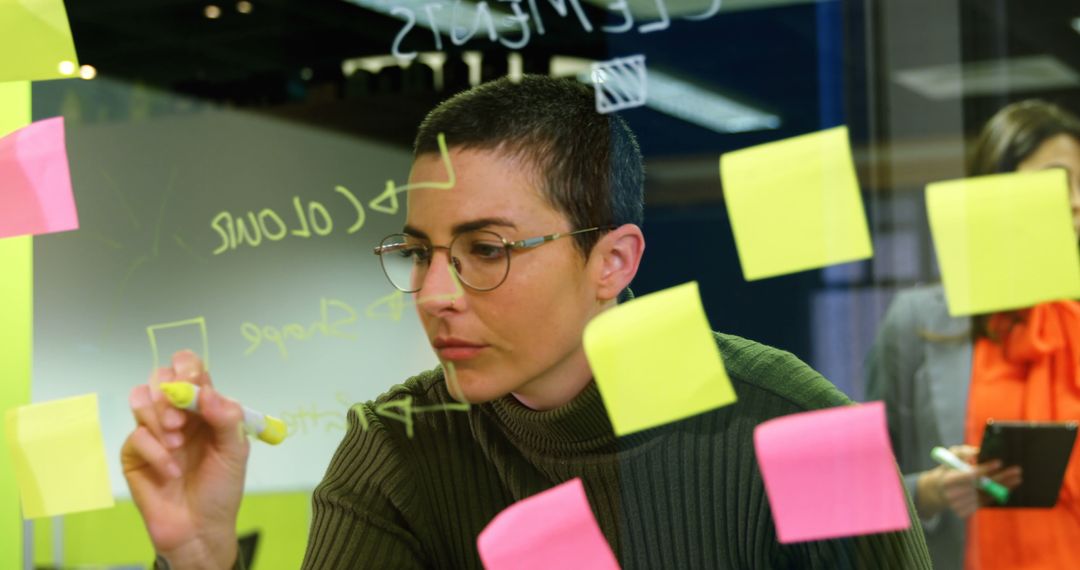 Focused Businesswoman Planning on Glassboard with Sticky Notes - Free Images, Stock Photos and Pictures on Pikwizard.com