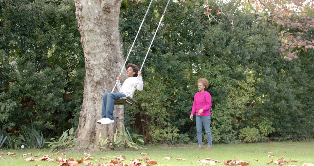 Mother and Son Enjoy Tree Swing Playtime in Backyard