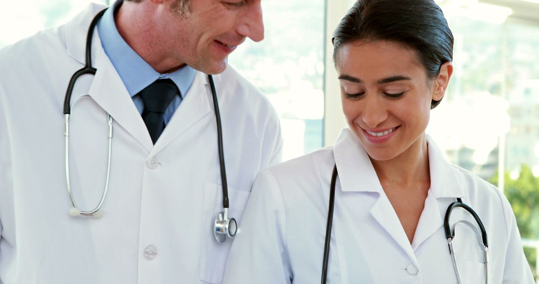 Two diverse doctors exemplify healthcare teamwork while studying medical data. - Free Images, Stock Photos and Pictures on Pikwizard.com