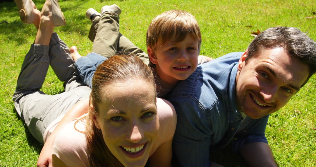 Happy Family Lying on Green Lawn Smiling Together - Free Images, Stock Photos and Pictures on Pikwizard.com