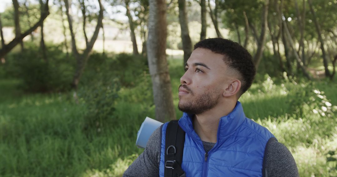 Hiker Exploring Sunny Forest in Blue Vest