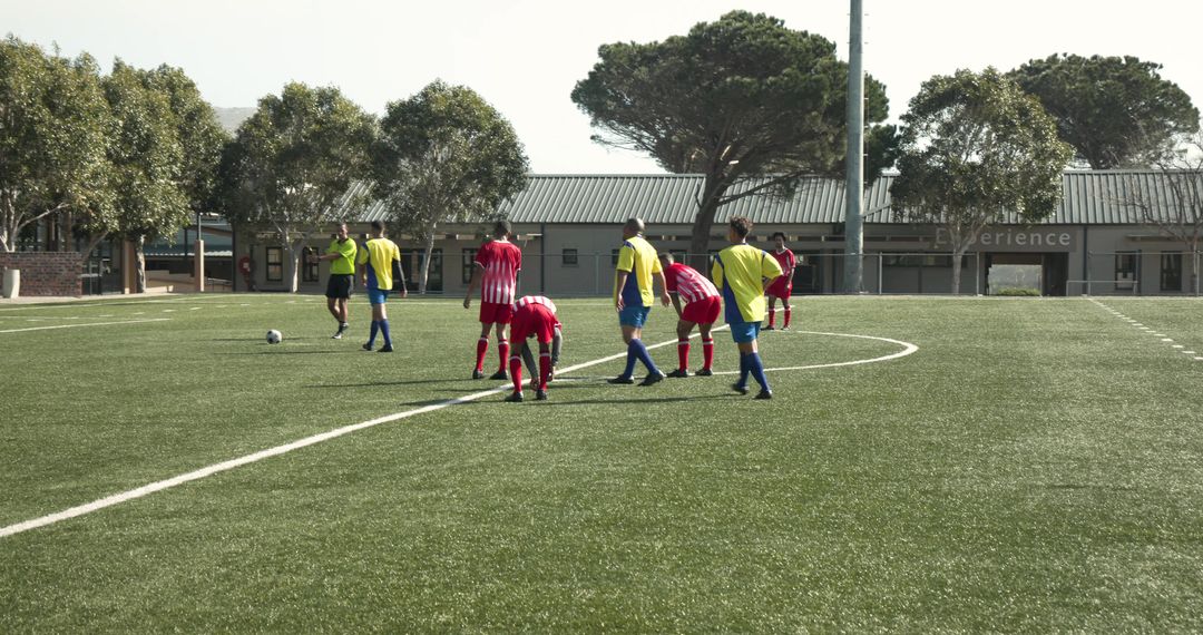 Soccer Players in Red Uniforms Preparing for Match on Sunny Day