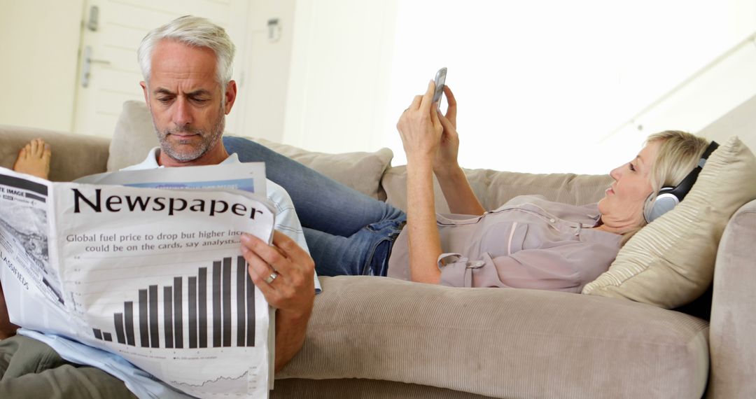 Couple Relaxing at Home with Newspaper and Music