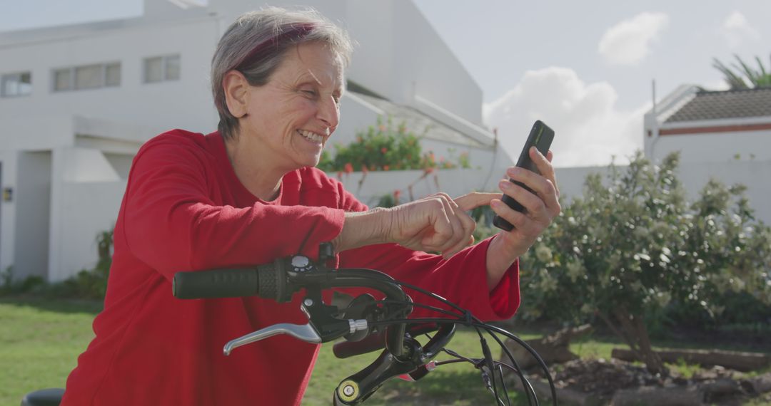 Elderly Woman Smiling While Using Smartphone Outdoors - Free Images, Stock Photos and Pictures on Pikwizard.com