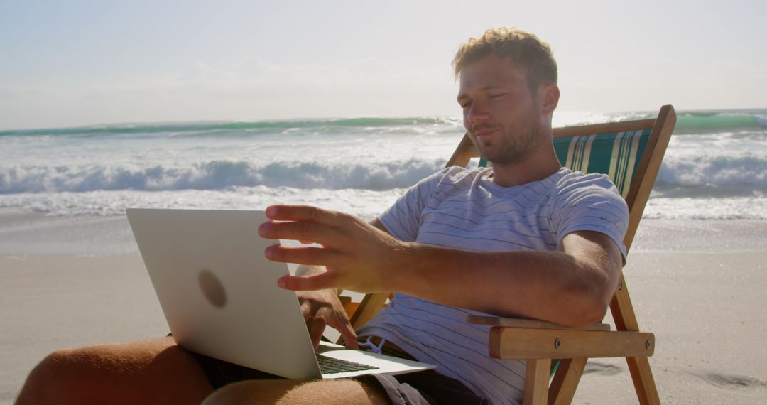 Man Working Remotely from Beach on Laptop