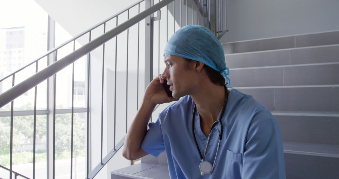 Medical Professional Taking Phone Call on Staircase - Free Images, Stock Photos and Pictures on Pikwizard.com