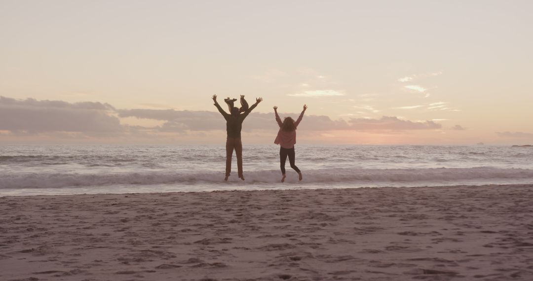 Couple Jumping on Beach at Sunset Celebrating Freedom - Free Images, Stock Photos and Pictures on Pikwizard.com